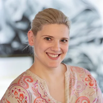 Porträt von Denkströme Geschäftsführerin Teresa Weber, lächelnd vor kreativem Agentur-Hintergrund