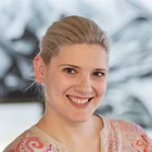 Porträt von Denkströme Geschäftsführerin Teresa Weber, lächelnd vor kreativem Agentur-Hintergrund