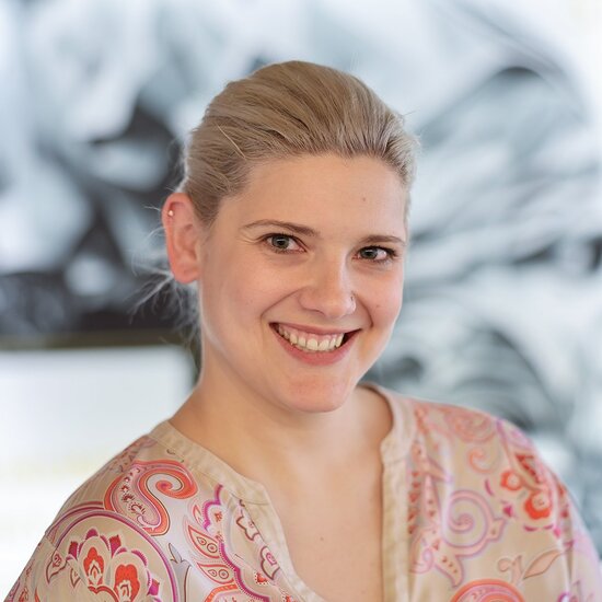 Porträt von Denkströme Geschäftsführerin Teresa Weber, lächelnd vor kreativem Agentur-Hintergrund